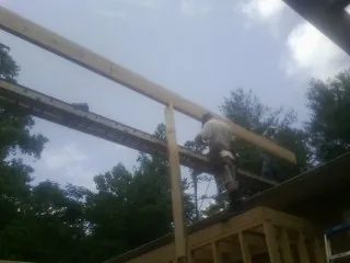Carpenter setting a ridge beam over a new addition frame — Ice Dam Removal by Roofing Brothers in Ft Mitchell