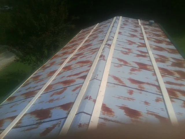 Rusted metal roof panels with new wood purlins before replacement — Storm Damage Roof Repair in Ft Mitchell by Roofing Brothers