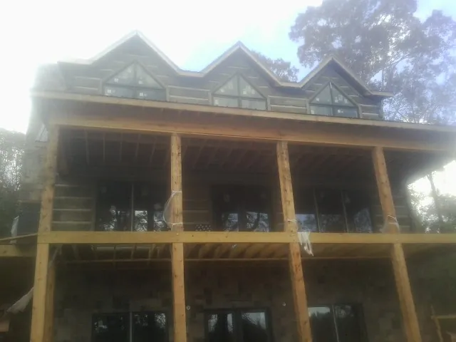 Dormers and porch framing on a large log home under construction — Roof Coating work by our crew in Ft Mitchell