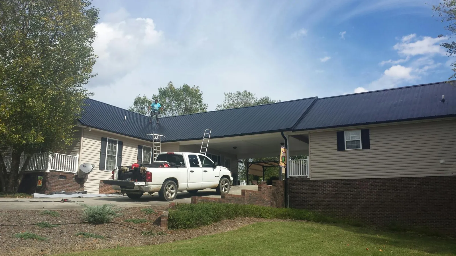 Black metal roof over a home and attached breezeway with ladders set in Ft Mitchell